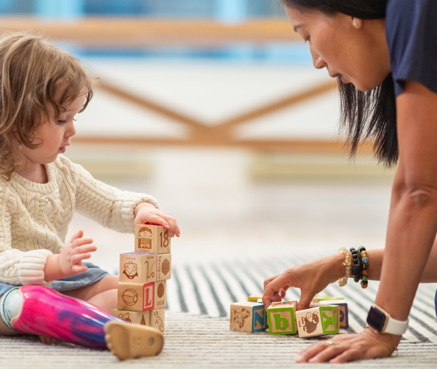 Woman and toddler playing with blocks